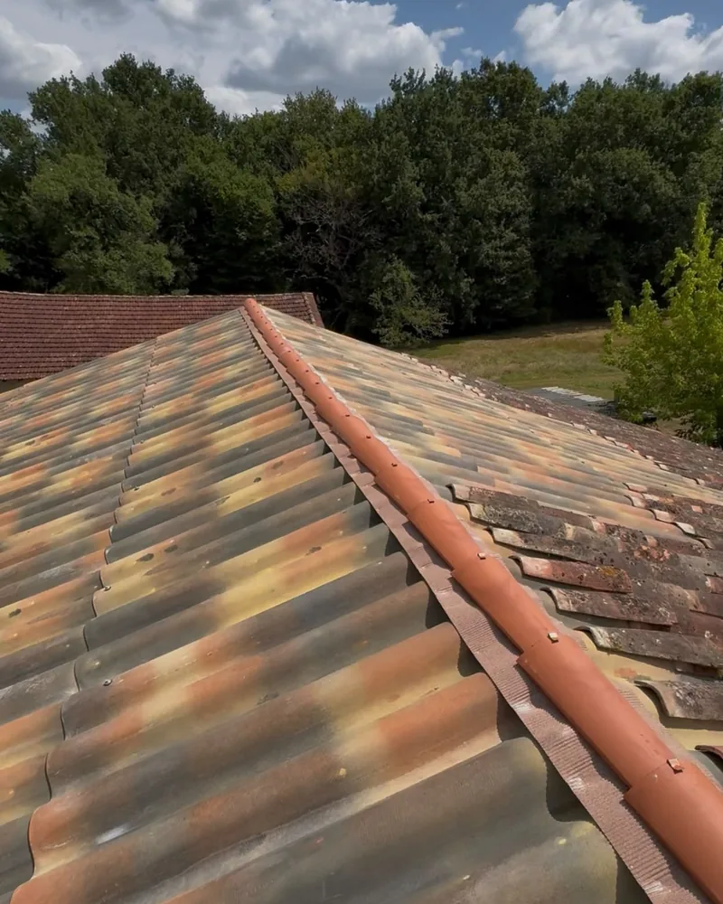 Faîtage en zinc neuf posé entre des tuiles anciennes patinées, à Agen